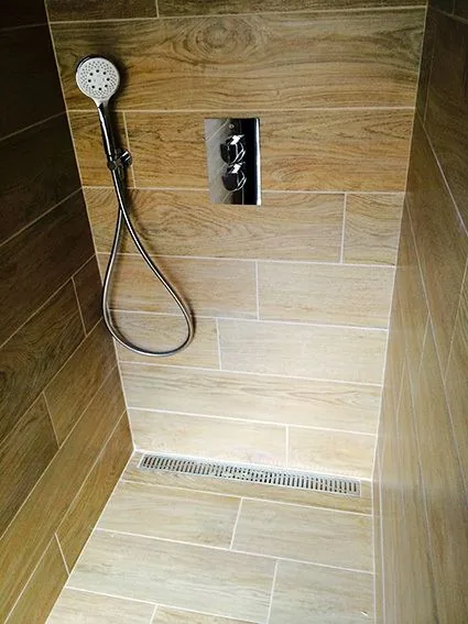 Douche à l'italienne carrelée imitation bois avec caniveau