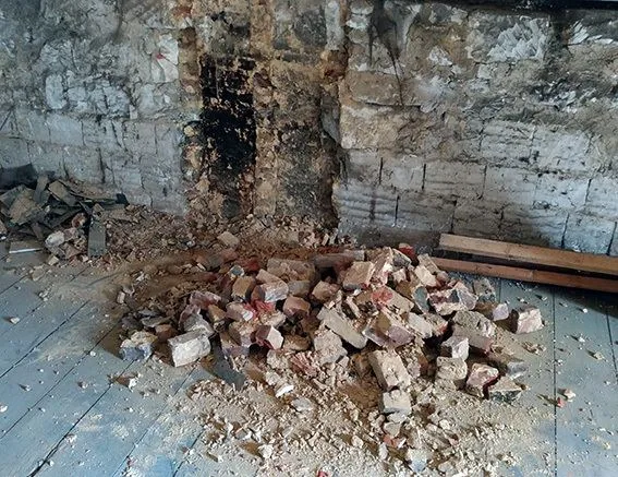 Mur en pierre mis à nu et gravats lors d'une dépose
