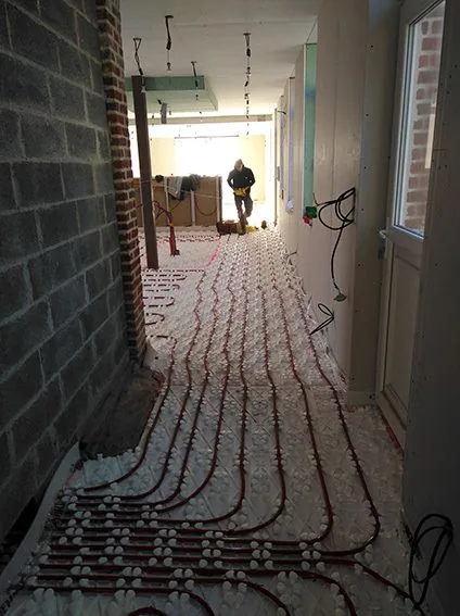 Plancher chauffant dans un couloir aux murs de briques
