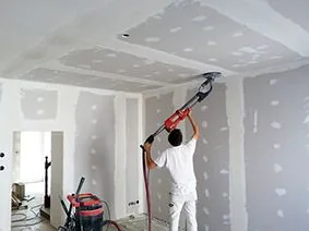 Plaquiste réalisant les bandes et joints d'un plafond en plâtre dans le Pas-de-Calais